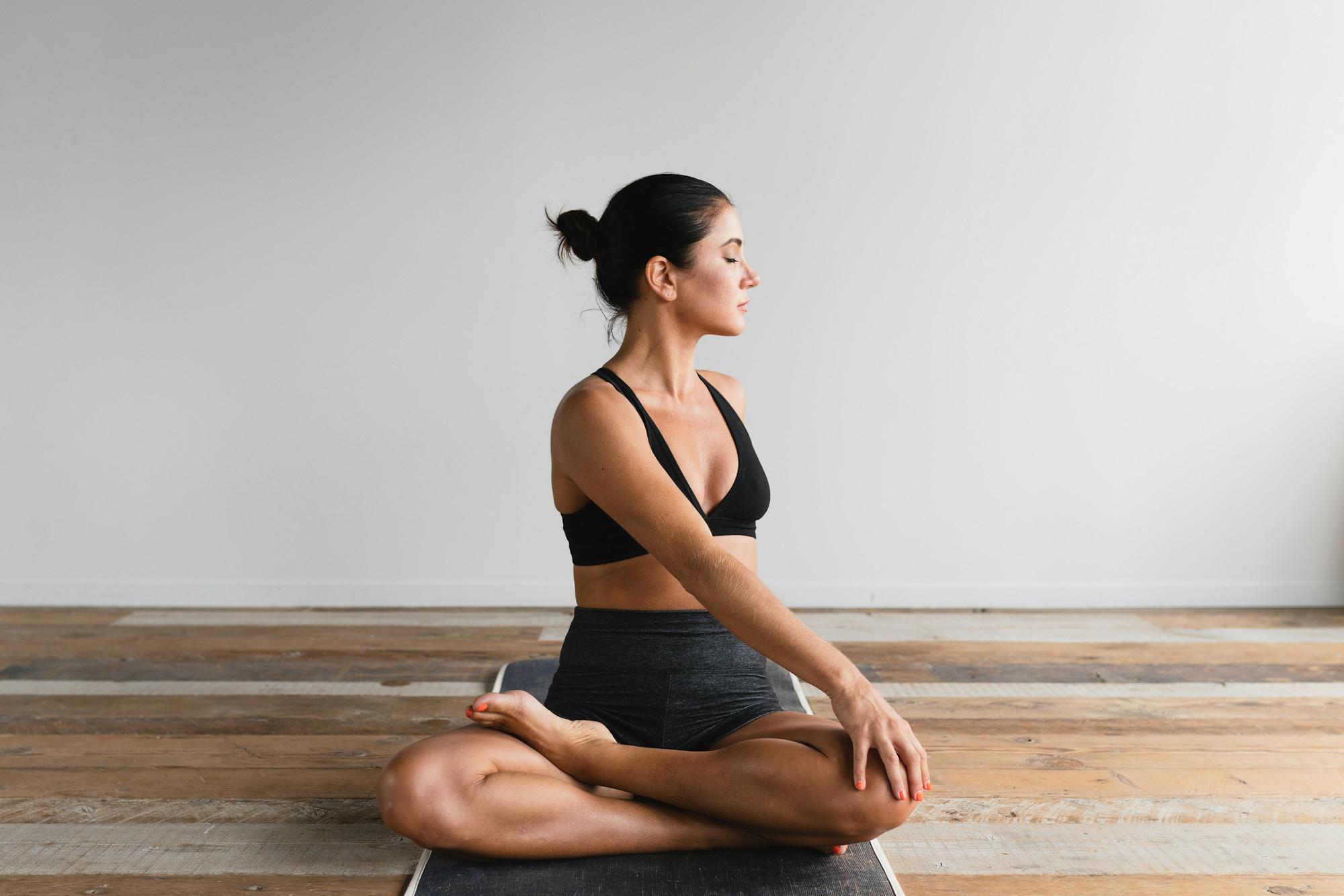 Pratiquante de Yin Yoga assise en posture calme sur son tapis